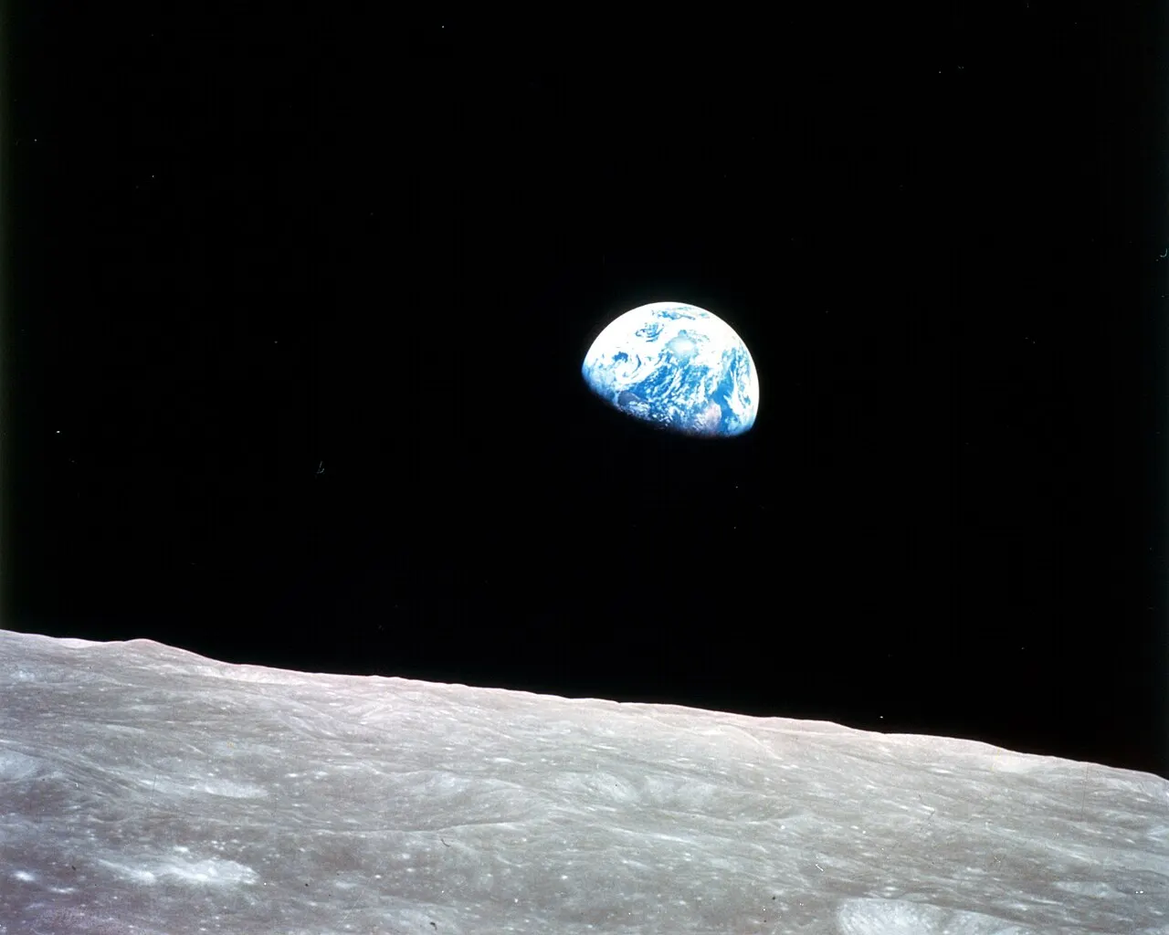 This view of the rising Earth greeted the Apollo 8 astronauts as they came from behind the Moon after the fourth nearside orbit. Earth is about five degrees abo