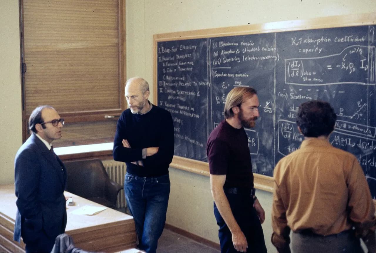 Discussion in the main lecture hall at the École de Physique des Houches (Les Houches Physics School), 1972. From left, Yuval Ne'eman, Bryce DeWitt, Kip Thorne.