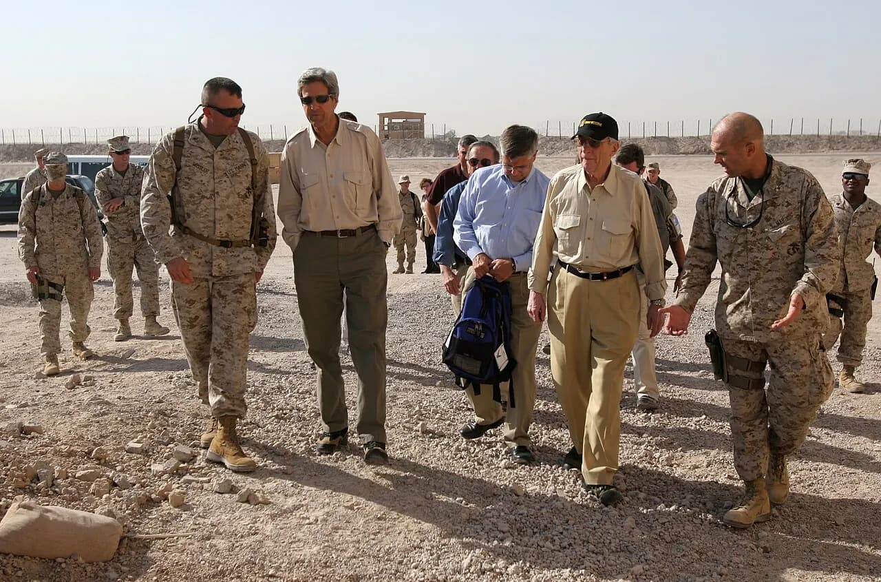 Camp Al Taqaddum, Iraq (Sept. 1, 2005) – U.S. Senators John Kerry of Massachusetts, Ted Stevens of Alaska, and Jon Warner of Virginia, walk with U.S. Marine Cor