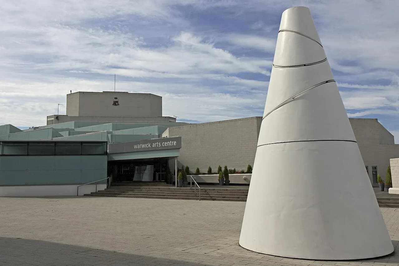 Warwick Arts Centre in Coventry, UK with "White Koan" in the foreground, a cone-shaped sculpture by Liliane Lijn.