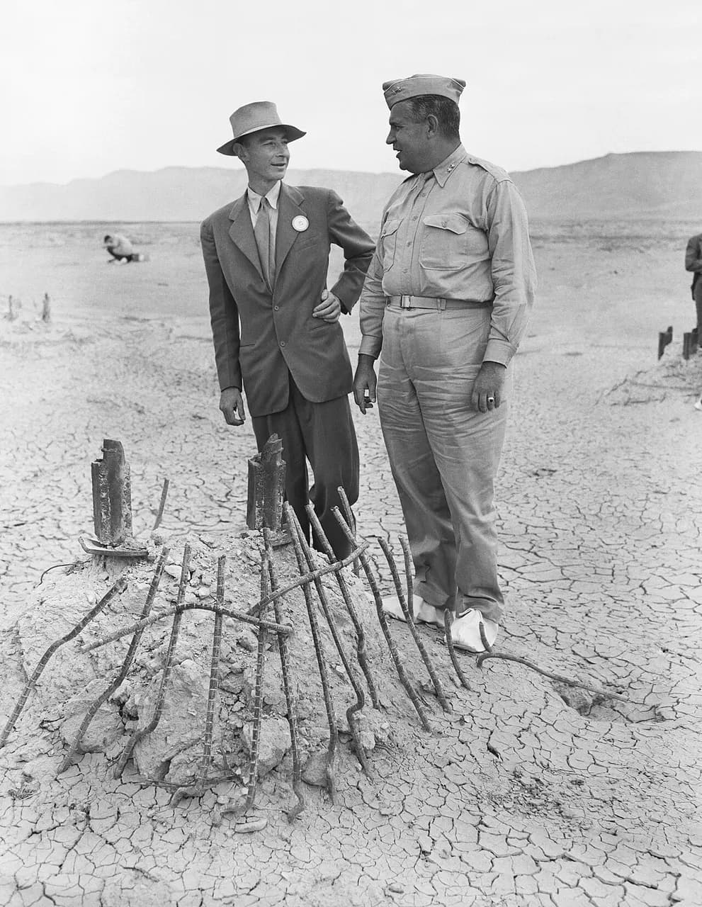 In September 1945, many participants returned to the Trinity Test site for news crews. Here Oppenheimer and Groves examine the remains of one the bases of the s